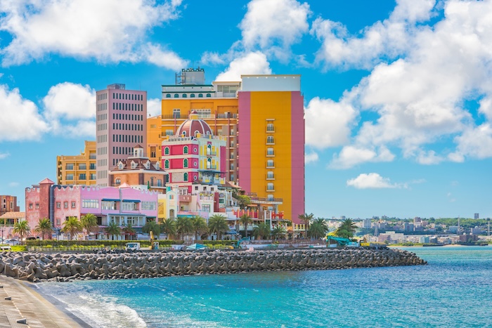 Beach coast lined with palm trees of Distortion Seaside, Oak fashion, Depot Island Seaside buildings and Vessel Hotel Campana in the vicinity of the American Village in Chatan City of Okinawa.